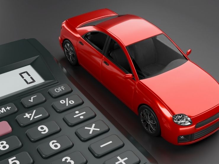 tavolo con calcolatrice e auto giocattolo, x in primo piano